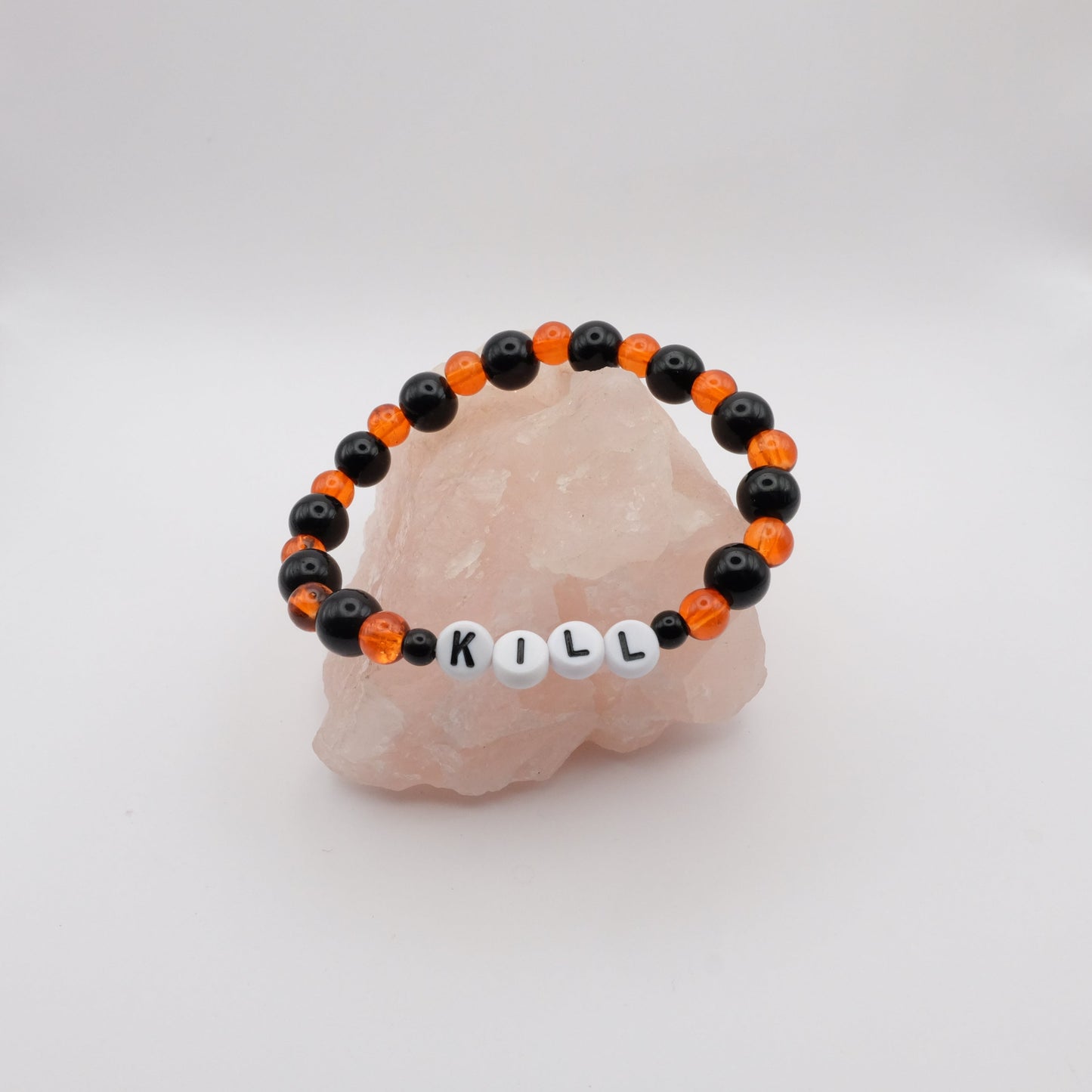 Black and orange beaded bracelet with 'KILL' on a white background