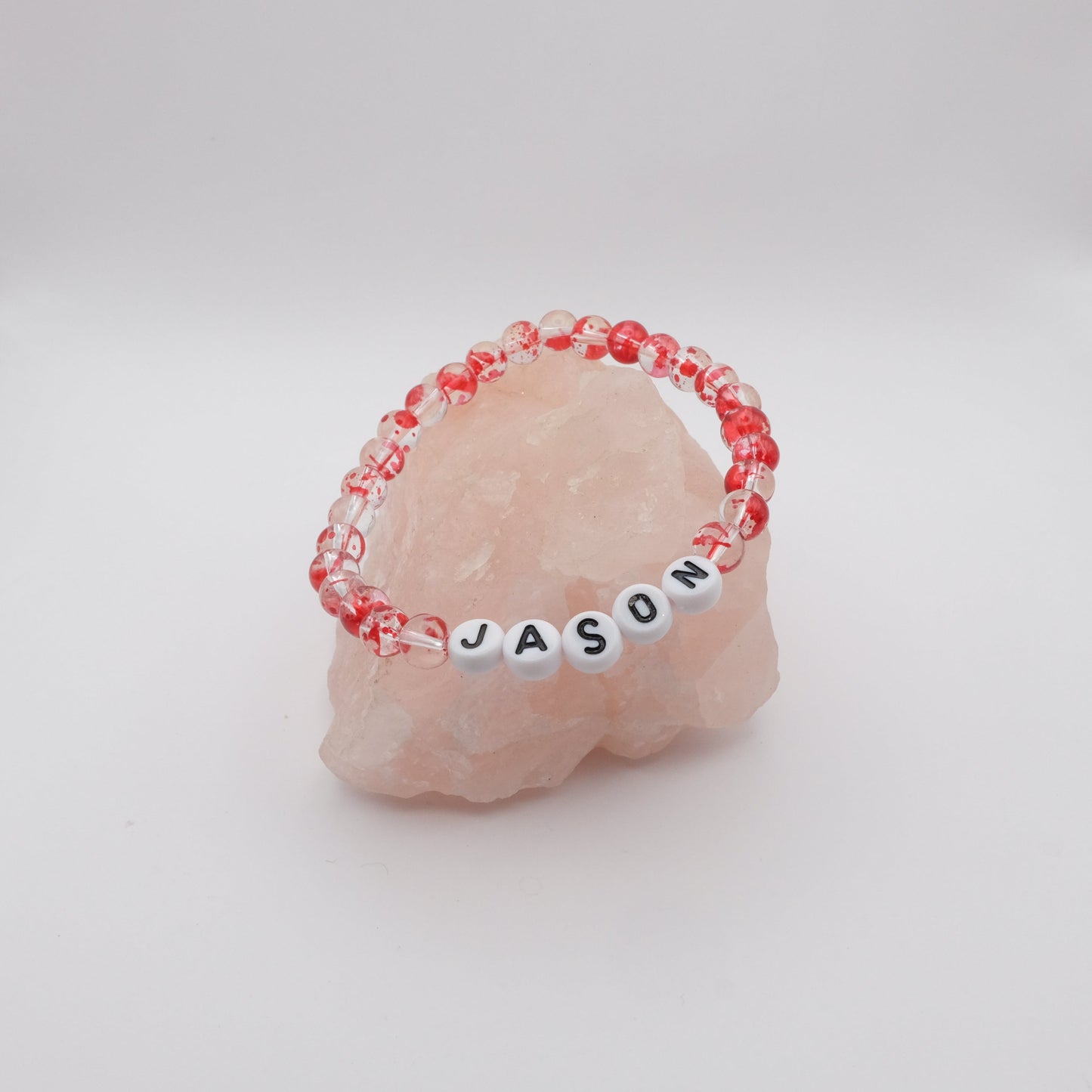 Bracelet with 'JASON' beads on a pink stone