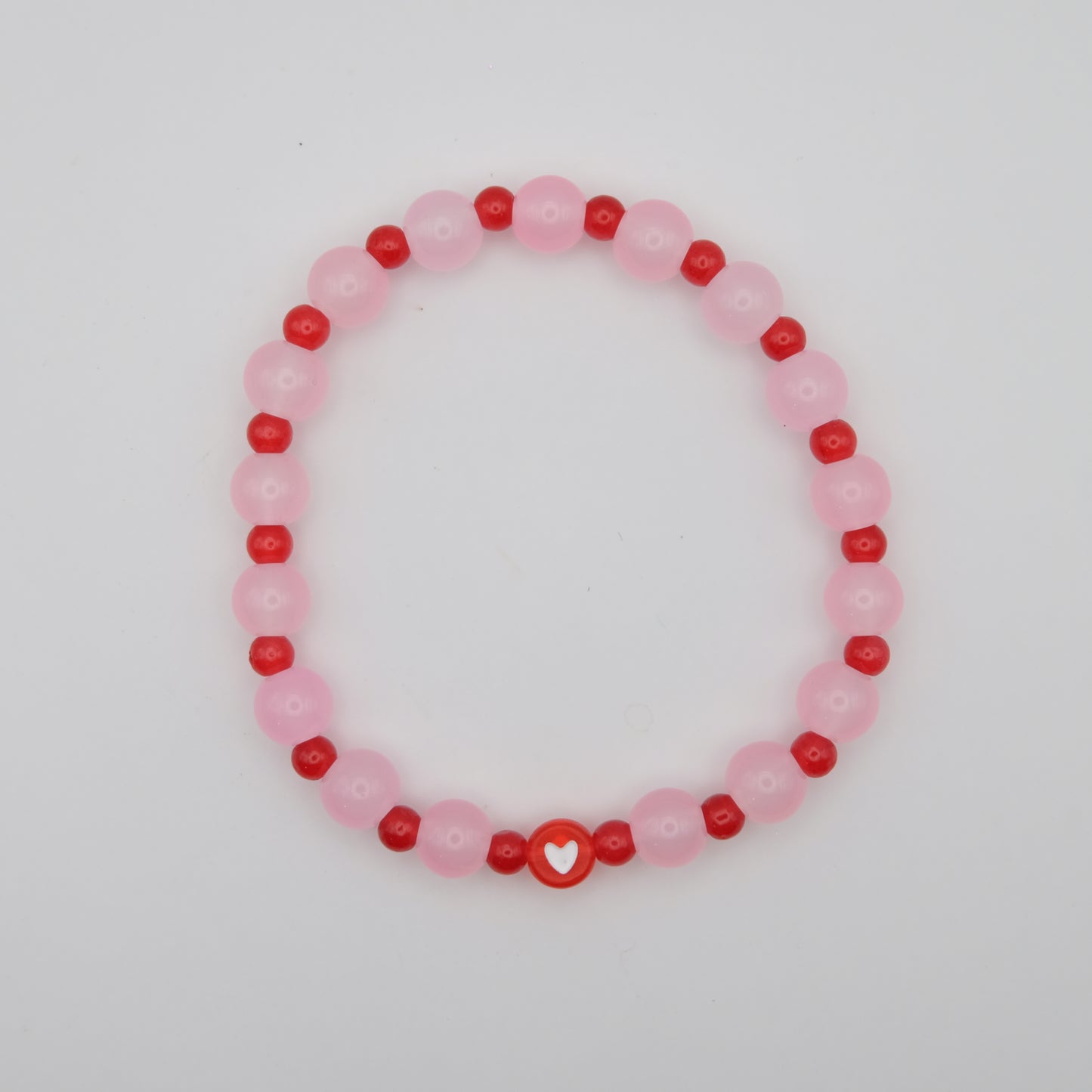 Beaded bracelet with pink and red beads on a white background