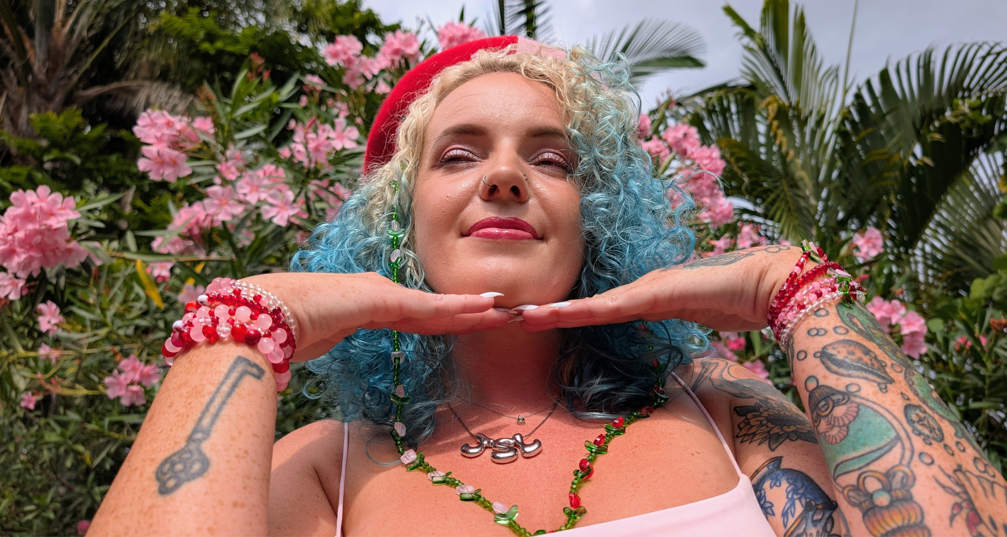A woman wears colourful bracelet stacks made from glass beads, showcasing handmade jewellery and dopamine dressing by Gold Coast quirky jewellery brand Velveteen Sunshine.