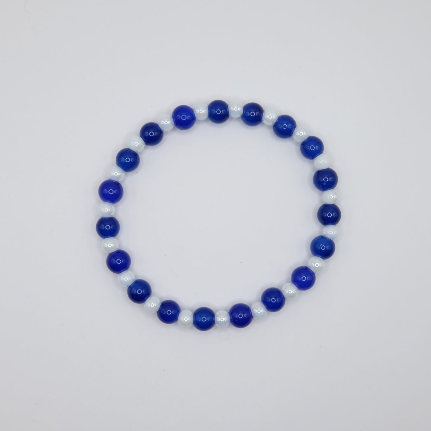 Beaded bracelet with blue and white beads on a light gray background