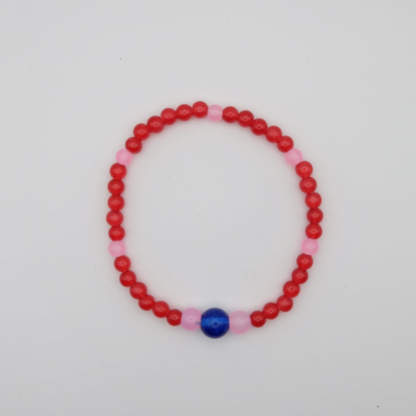 Beaded bracelet with red and pink beads on a white background
