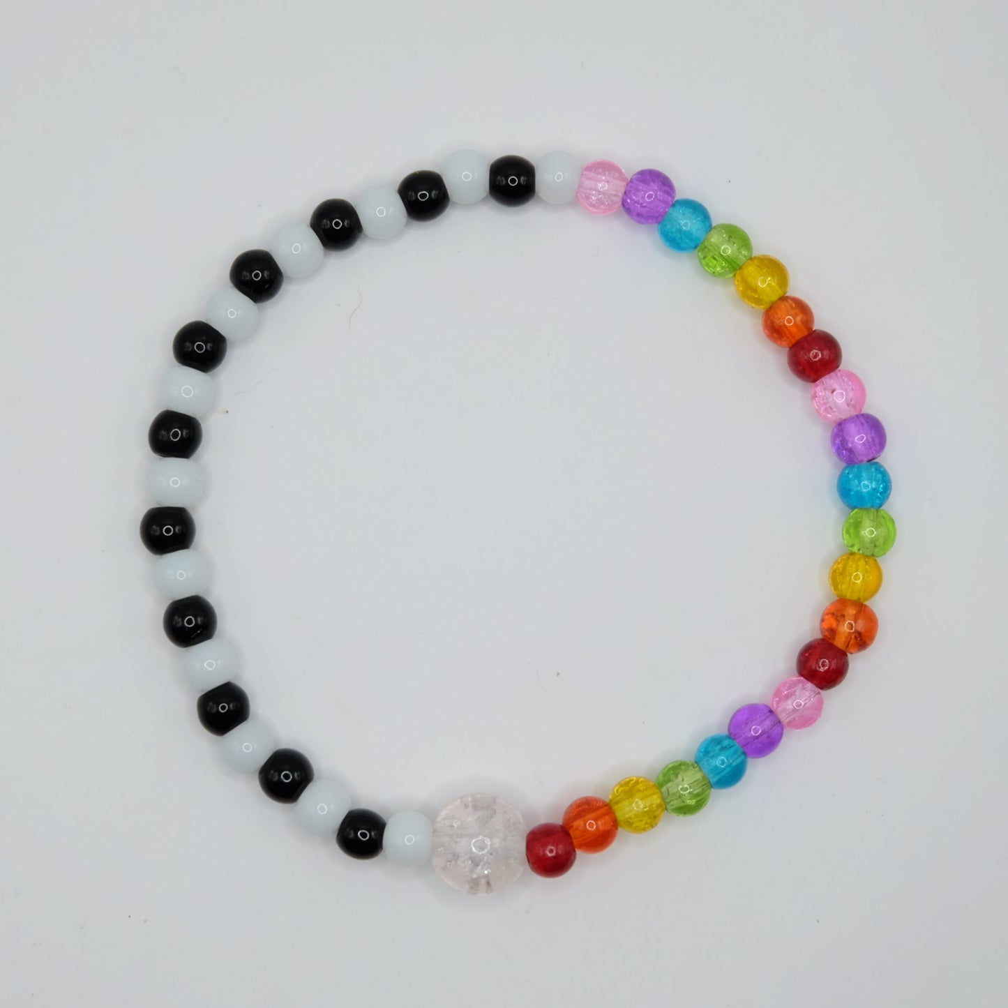Beaded bracelet with black, white, and multicolored beads on a light gray background