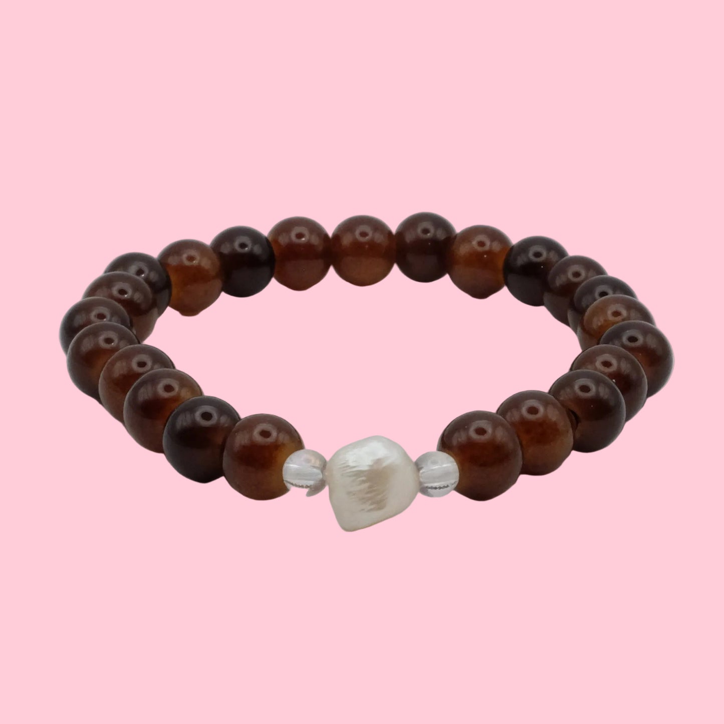 An elastic beaded bracelet composed of 6mm translucent cocoa and chestnut brown glass beads, featuring a freshwater pearl focal bead framed by clear accent beads, shown on a clean white background.