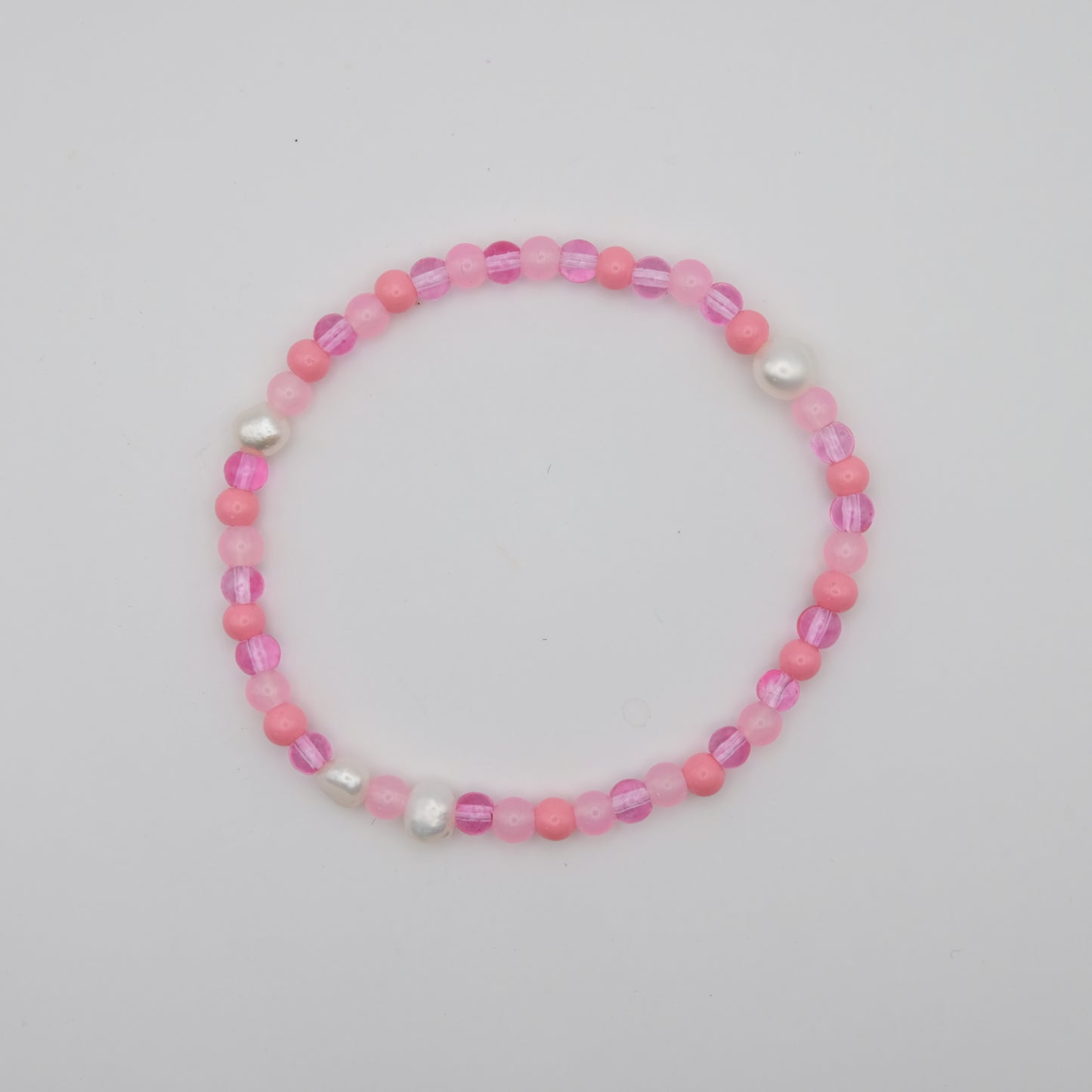 Pink beaded bracelet on a light gray background