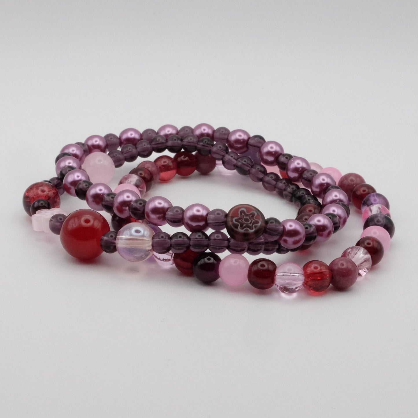 Set of multicolored beaded bracelets on a light gray background