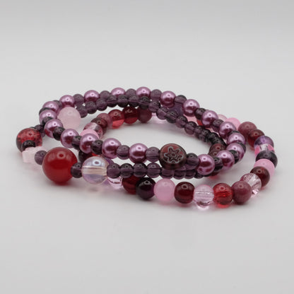 Set of multicolored beaded bracelets on a light gray background