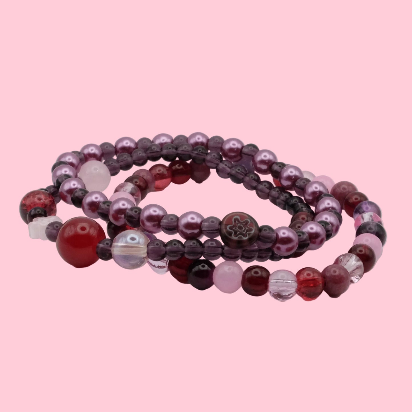 Layered bracelet stack featuring dark plum glass beads, wine red accents, crystal beads and rich berry tones.