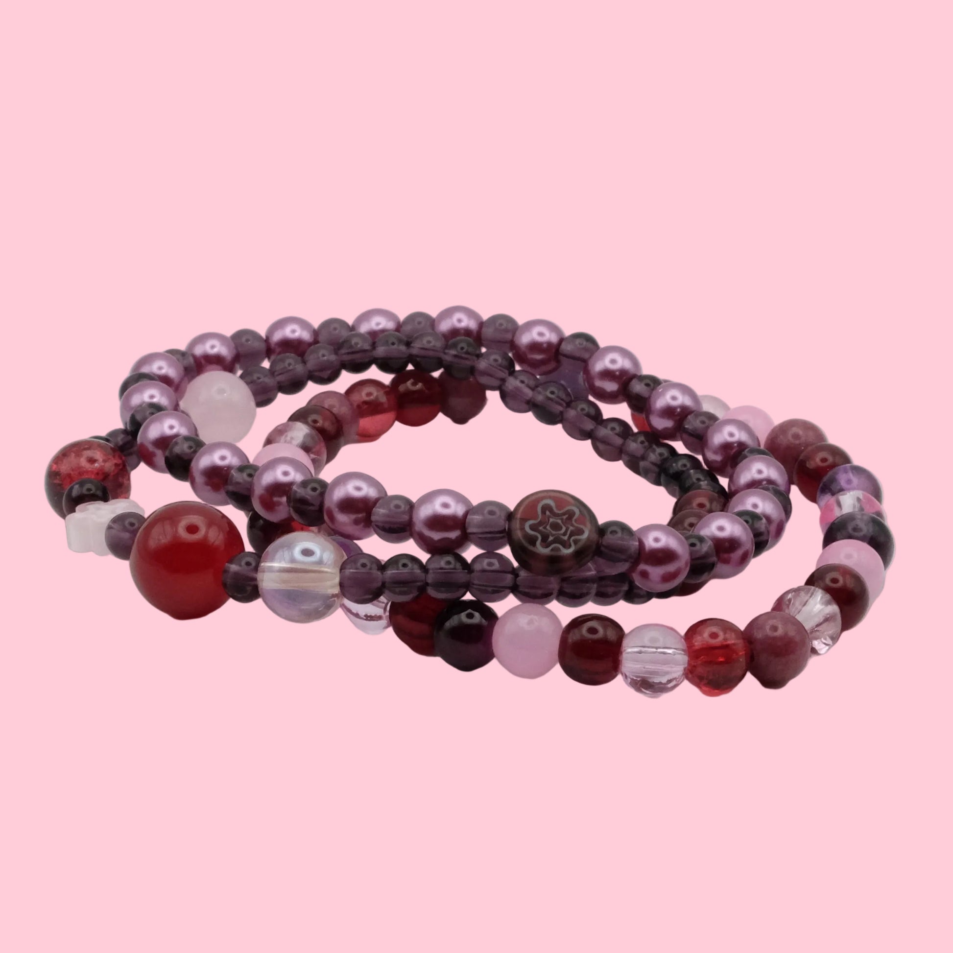 Layered bracelet stack featuring dark plum glass beads, wine red accents, crystal beads and rich berry tones.