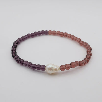 Beaded bracelet with a pearl on a light gray background