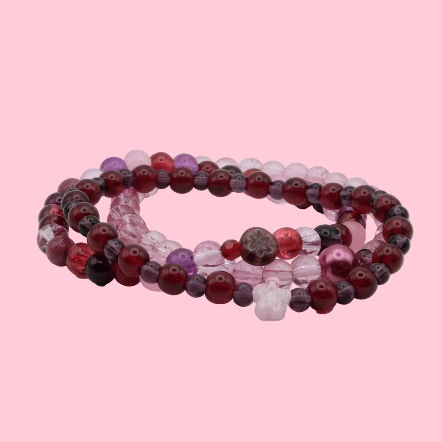 Handmade bracelet stack featuring deep cherry red glass beads, plum accents, blush pink beads and floral details from Satin Static.