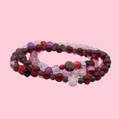 Handmade bracelet stack featuring deep cherry red glass beads, plum accents, blush pink beads and floral details from Satin Static.