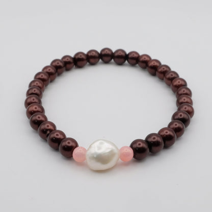 Bracelet with brown beads and a pearl on a light gray background