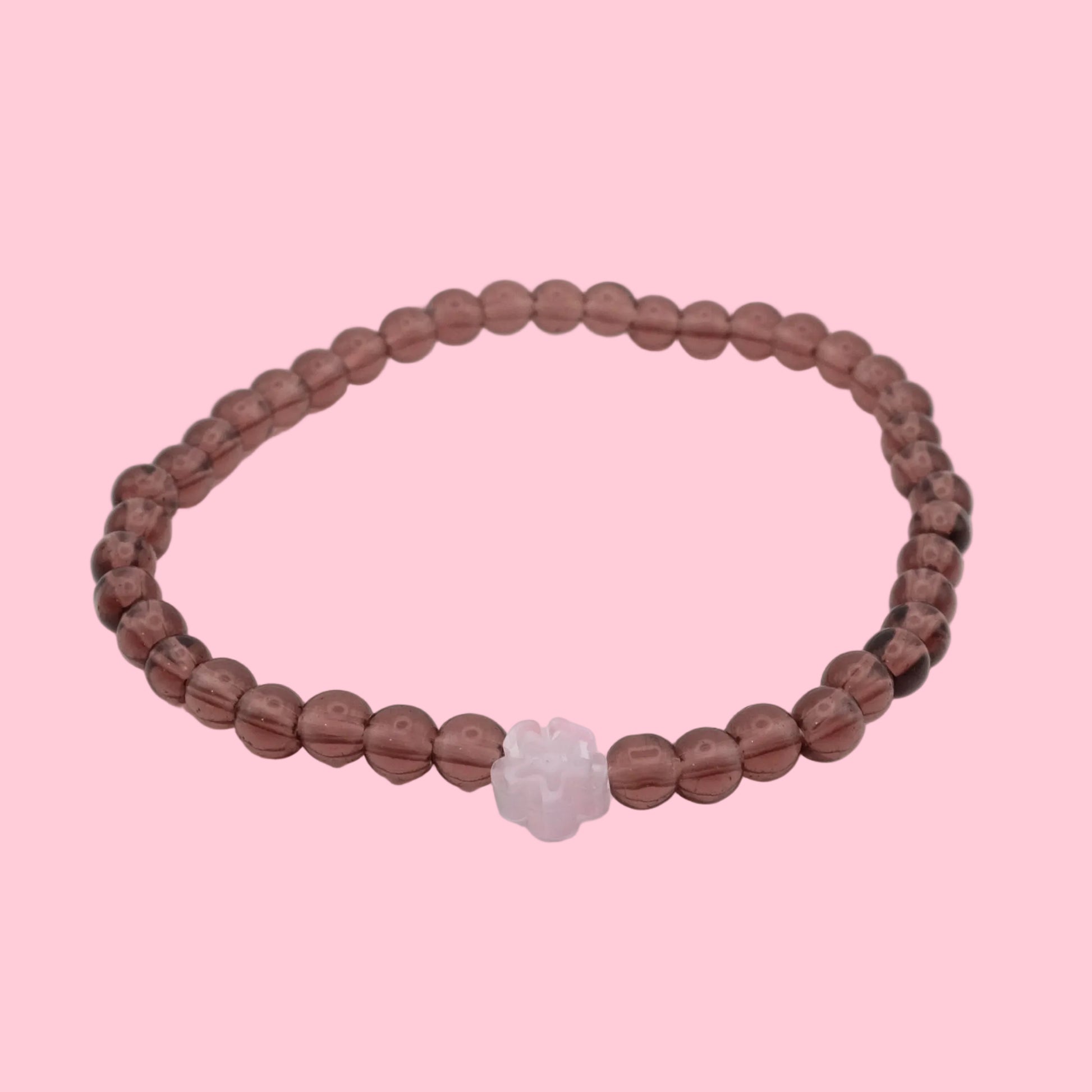 An elastic beaded bracelet composed of light burgundy 4mm glass beads, featuring a single translucent pink flower bead at the centre, shown on a white background.