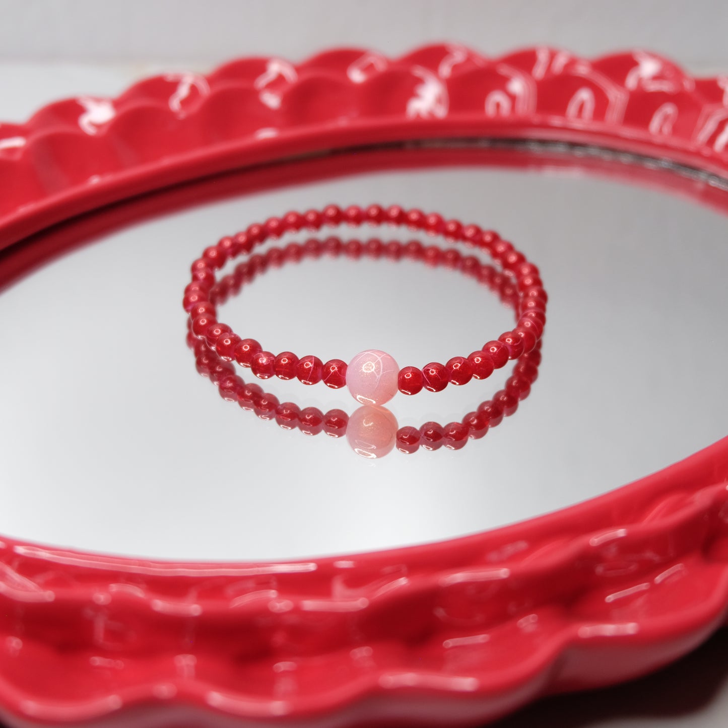 Red beaded bracelet on a red decorative plate