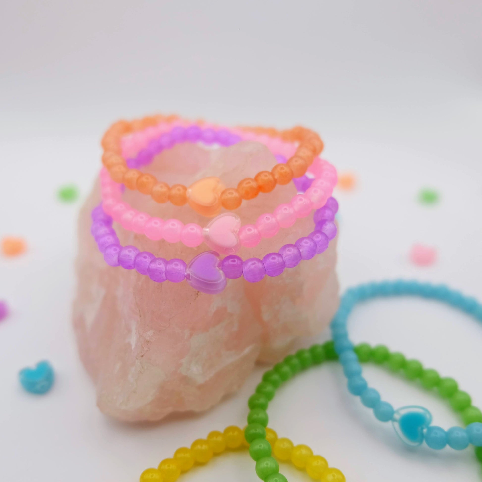 Colorful beaded bracelets on a white background with decorative elements.