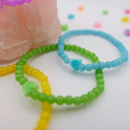 Three colorful beaded bracelets on a white background