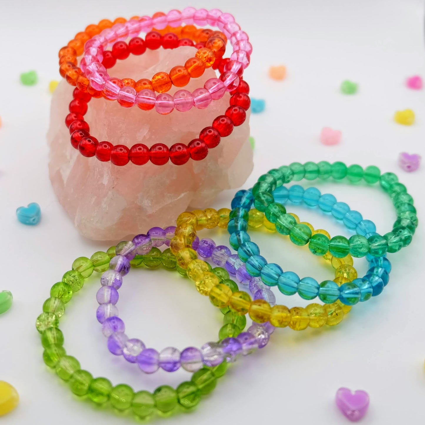 Colorful beaded bracelets on a white background with small heart-shaped beads.