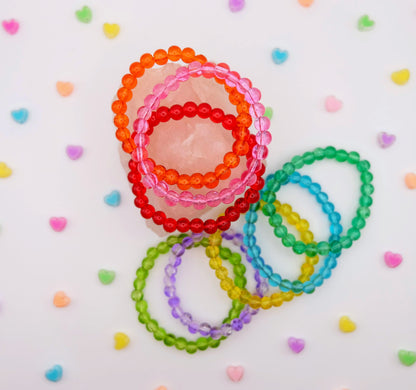 Colorful beaded bracelets on a white background with heart shapes.