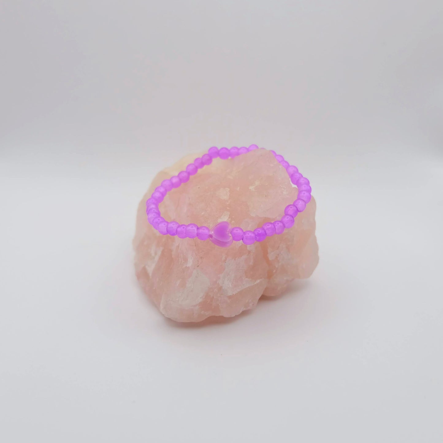 Pink crystal bracelet on a pink crystal with a white background
