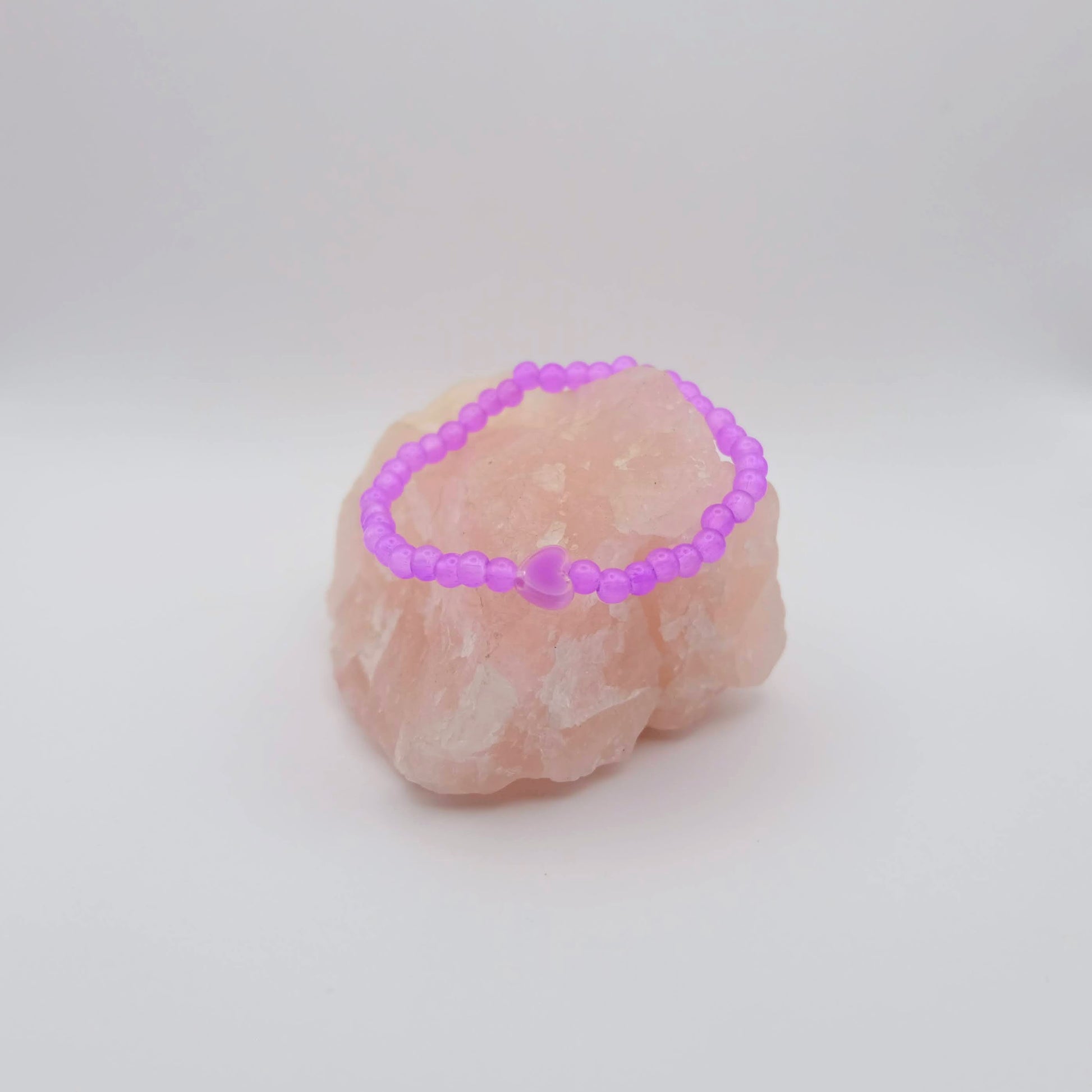 Pink crystal bracelet on a pink crystal with a white background