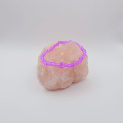 Pink crystal bracelet on a pink crystal with a white background