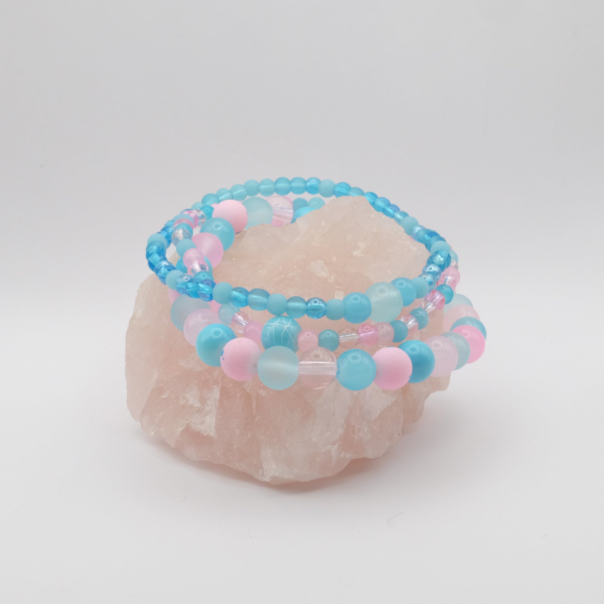 Beaded bracelet with blue and pink beads on a white background