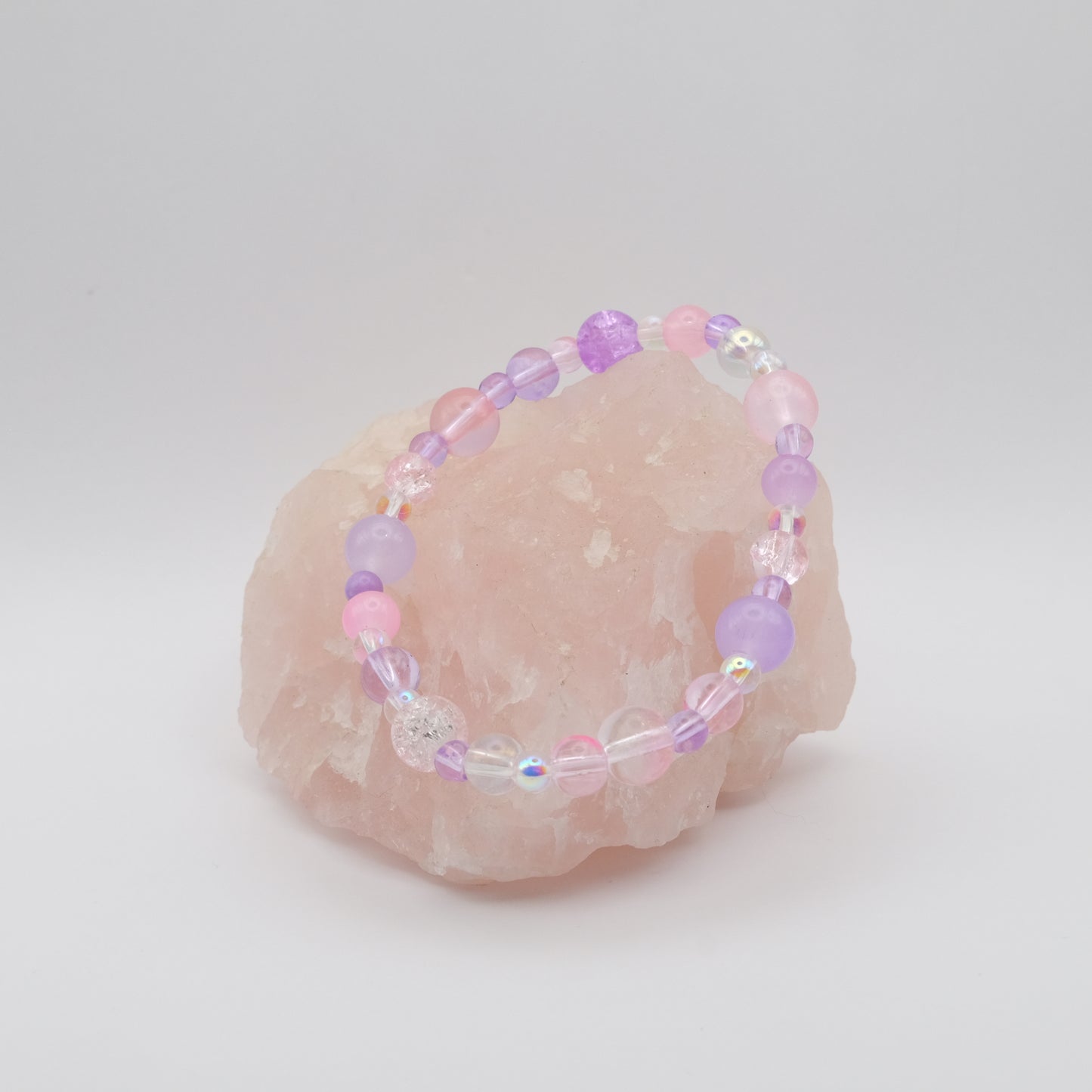 Beaded bracelet with pink and purple beads on a white background