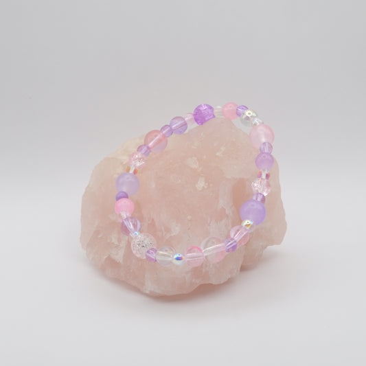 Beaded bracelet with pink and purple beads on a white background