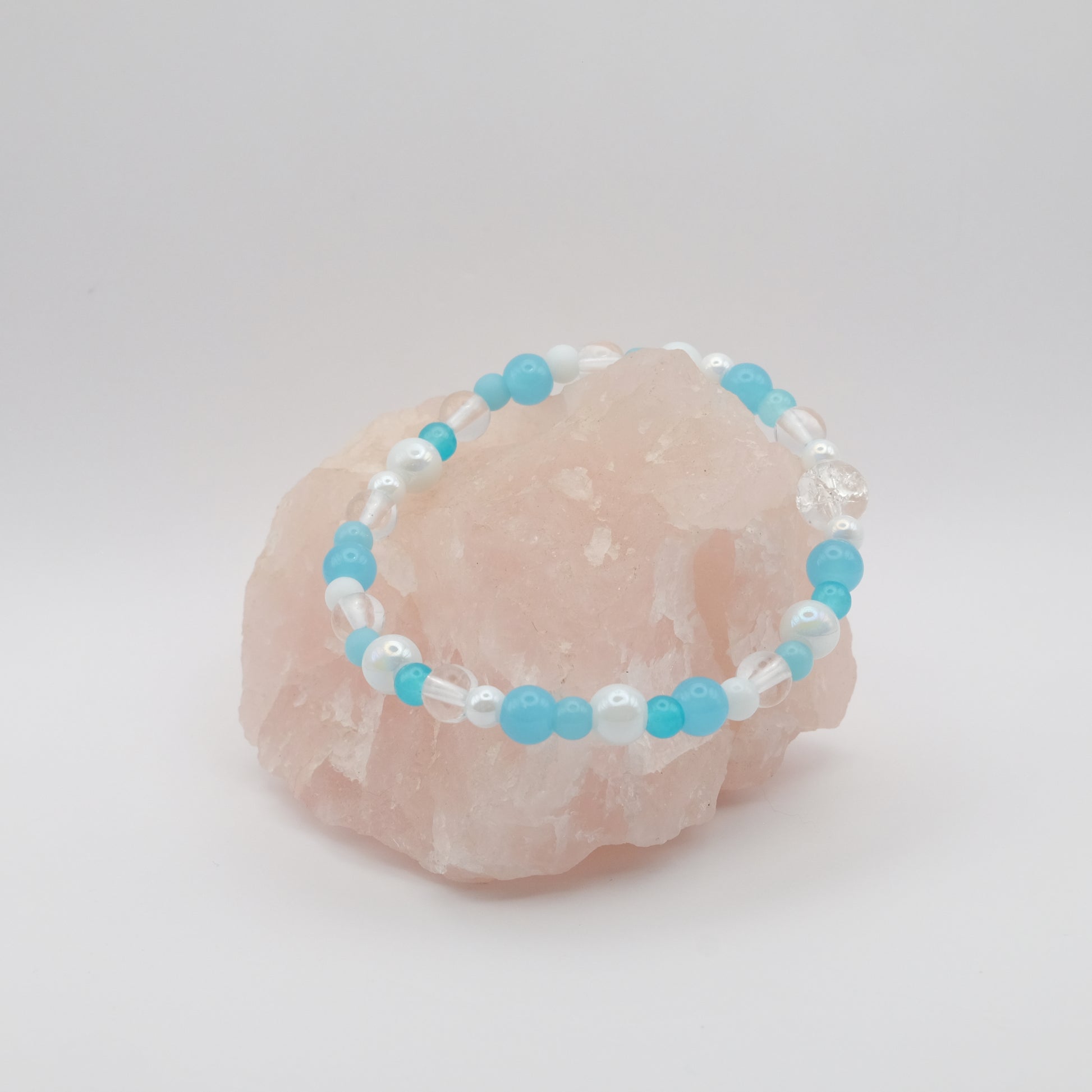 Beaded bracelet with blue and white beads on a pink stone