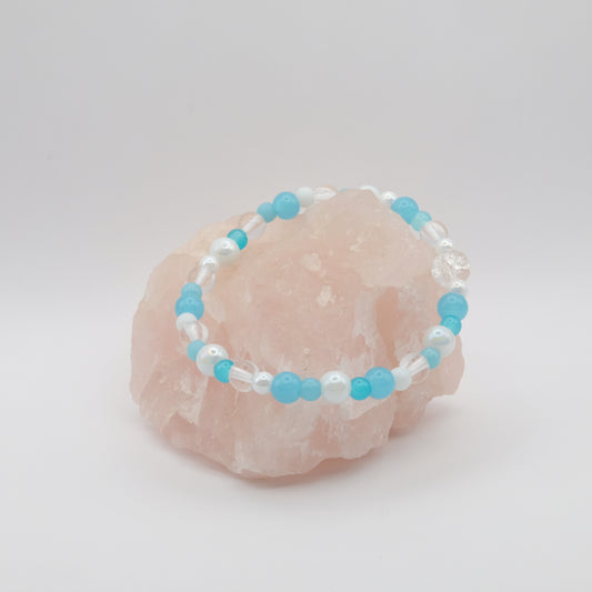 Beaded bracelet with blue and white beads on a pink stone