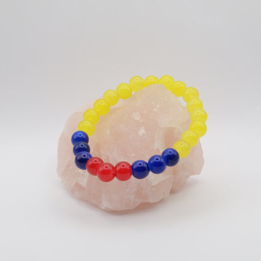 Colorful beaded bracelet on a pink stone with a white background