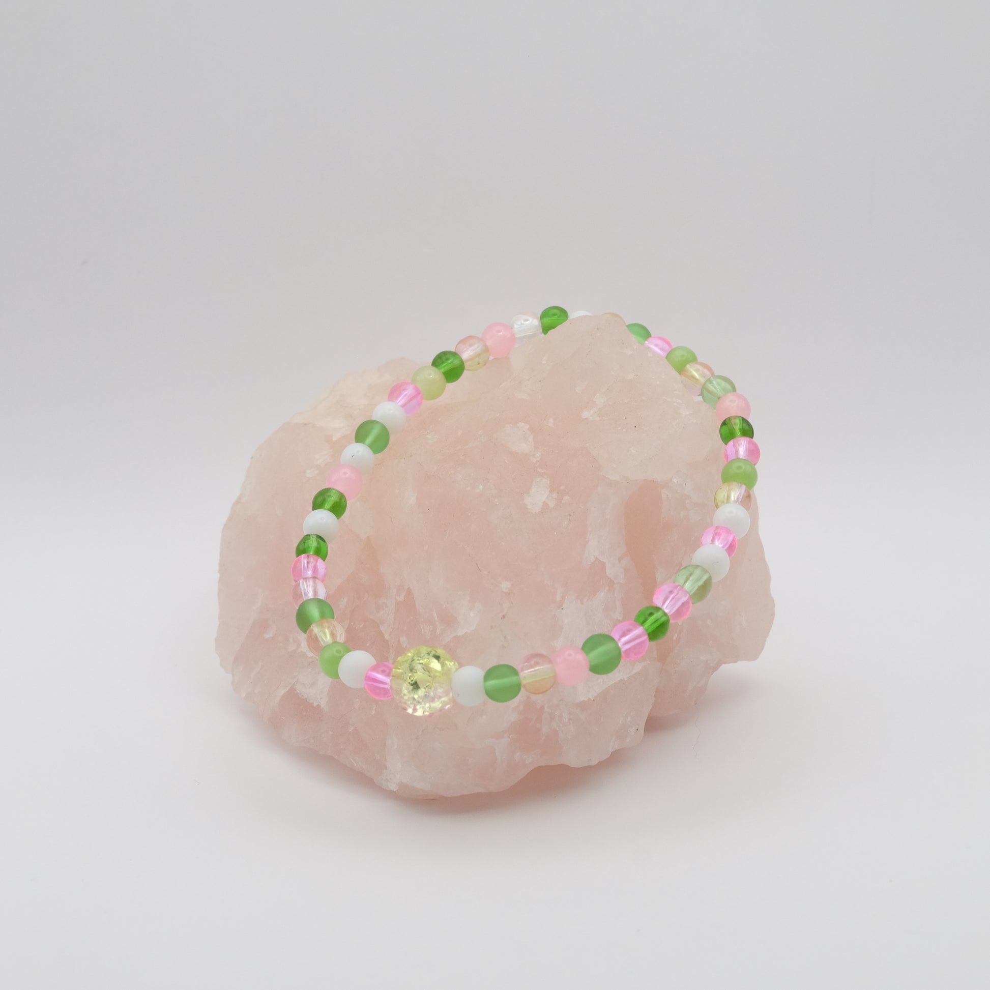 Beaded bracelet with pink and green beads on a pink stone