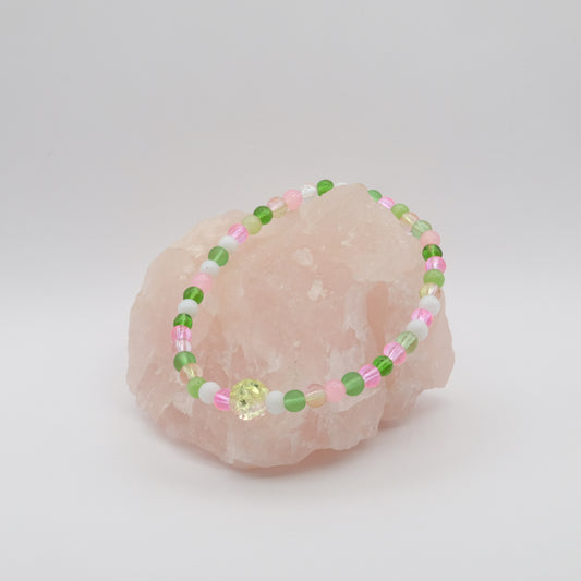 Beaded bracelet with pink and green beads on a pink stone