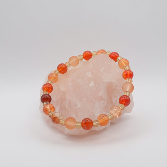 Beaded bracelet with orange and beige beads on a pink stone