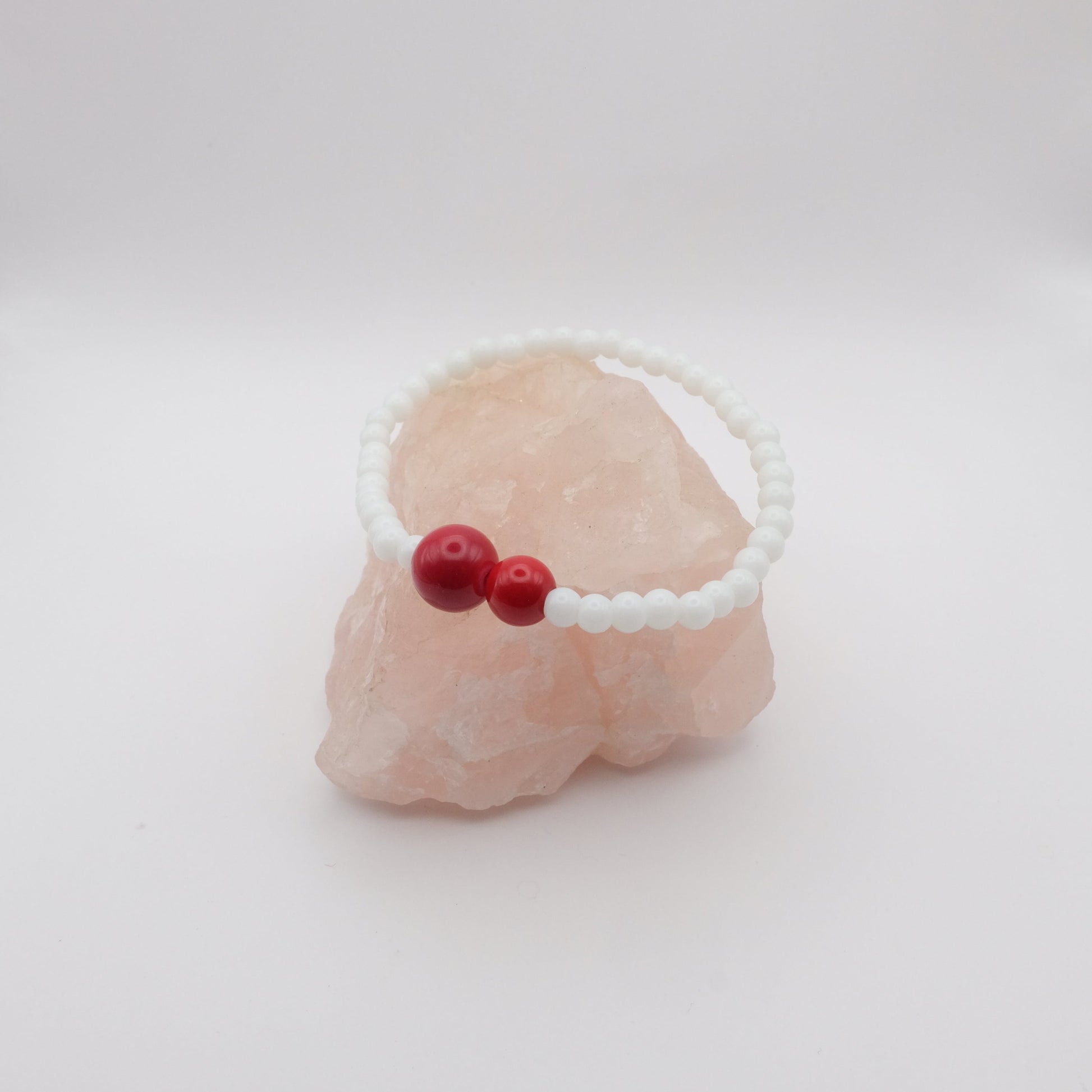 Bracelet with red beads on a white background
