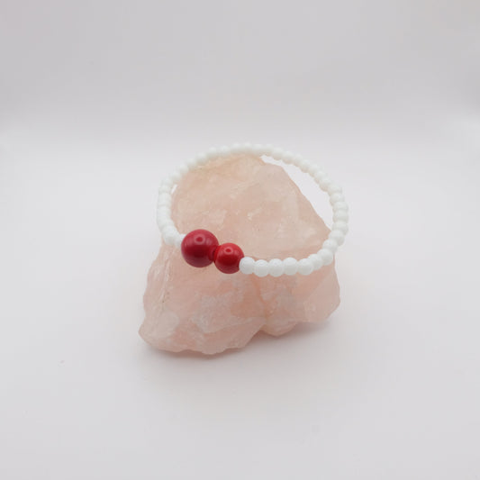 Bracelet with red beads on a white background