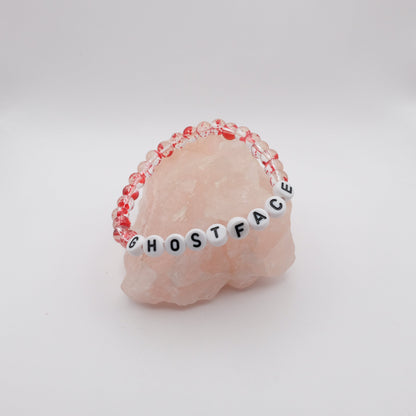 Bracelet with 'GHOSTFACE' beads on a pink stone background
