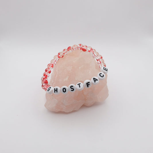 Bracelet with 'GHOSTFACE' beads on a pink stone background