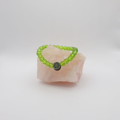 Green beaded bracelet with a black spiderweb bead on a white stone