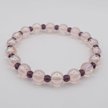 Beaded bracelet with pink and purple beads on a light gray background