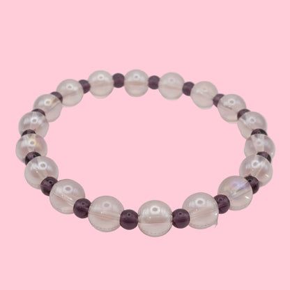 An elastic beaded bracelet composed of translucent light pink 8mm glass beads and deep purple 4mm glass beads, shown on a white background.