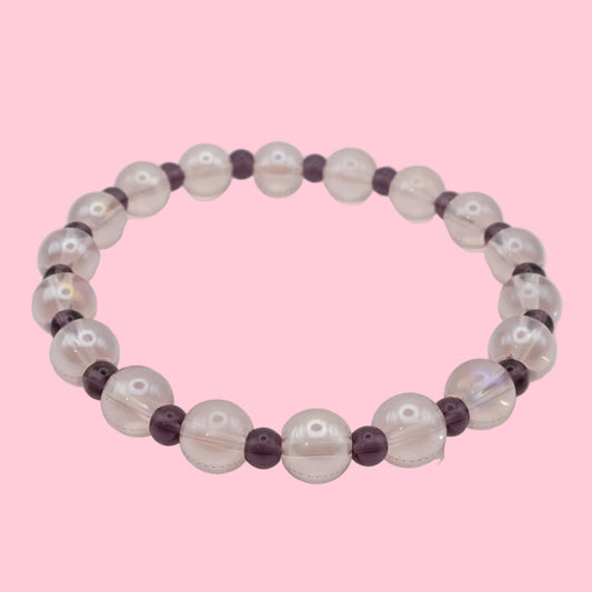 An elastic beaded bracelet composed of translucent light pink 8mm glass beads and deep purple 4mm glass beads, shown on a white background.