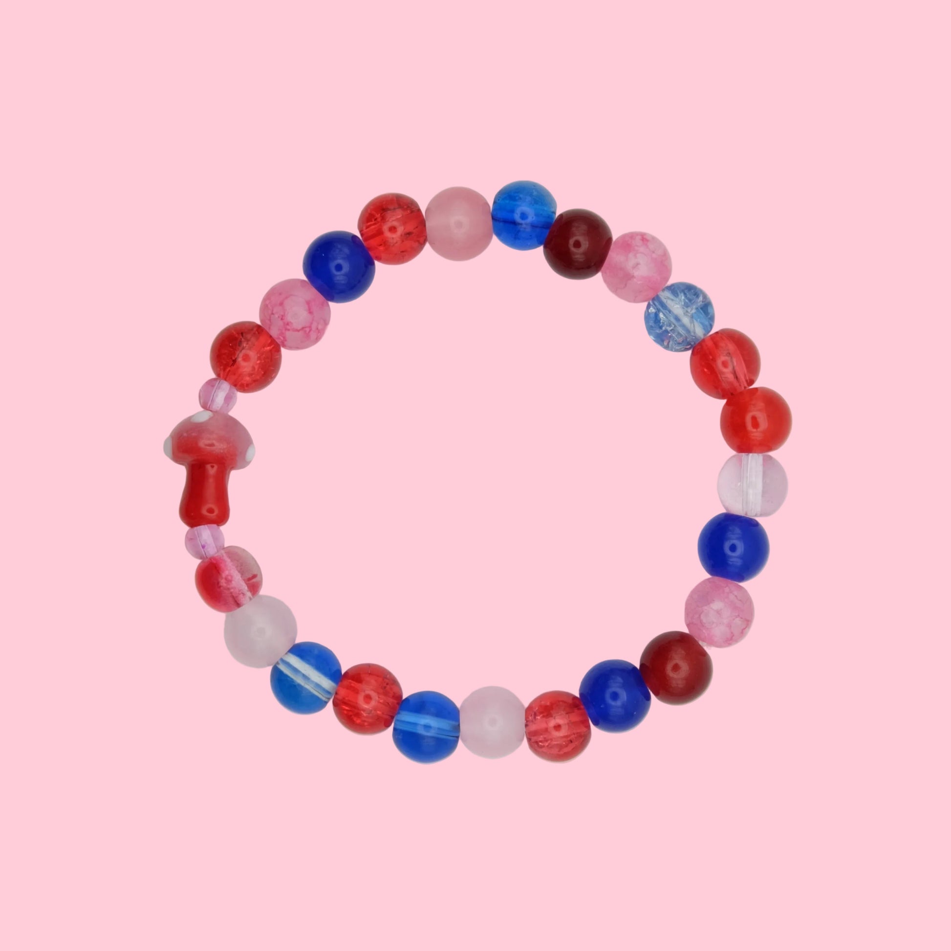 An elastic beaded bracelet composed of 8mm glass beads in red, pink and blue tones - featuring a blown glass toadstool bead, shown on a white background.