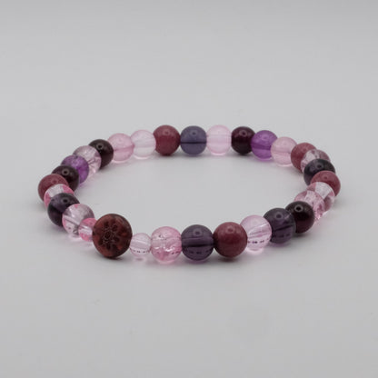 Beaded bracelet with purple and pink beads on a light gray background