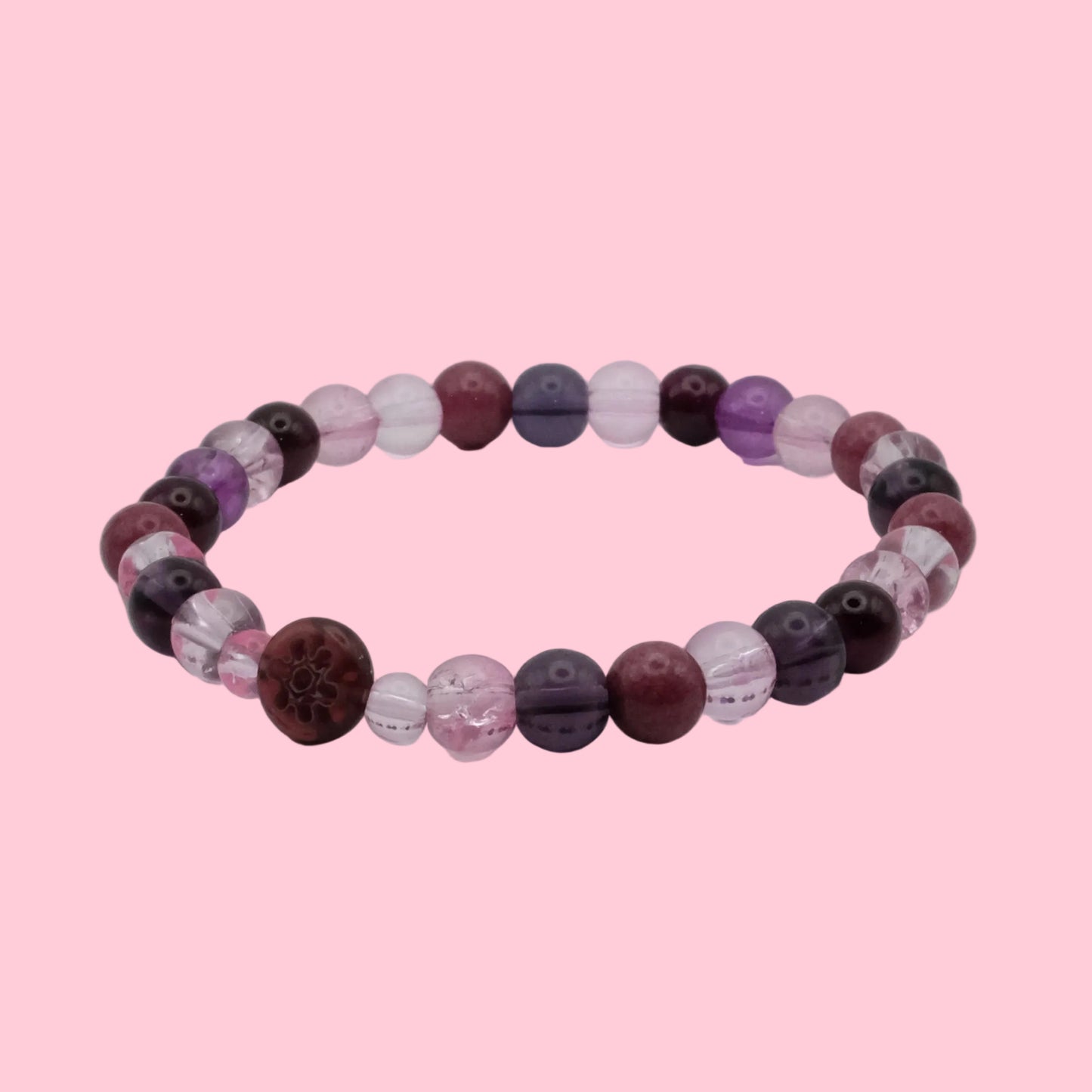 An elastic beaded bracelet composed of 6mm blush pink, plum, mauve and deep burgundy beads, featuring a mix of translucent, frosted and marbled finishes with a burgundy floral accent bead, shown on a clean white background.