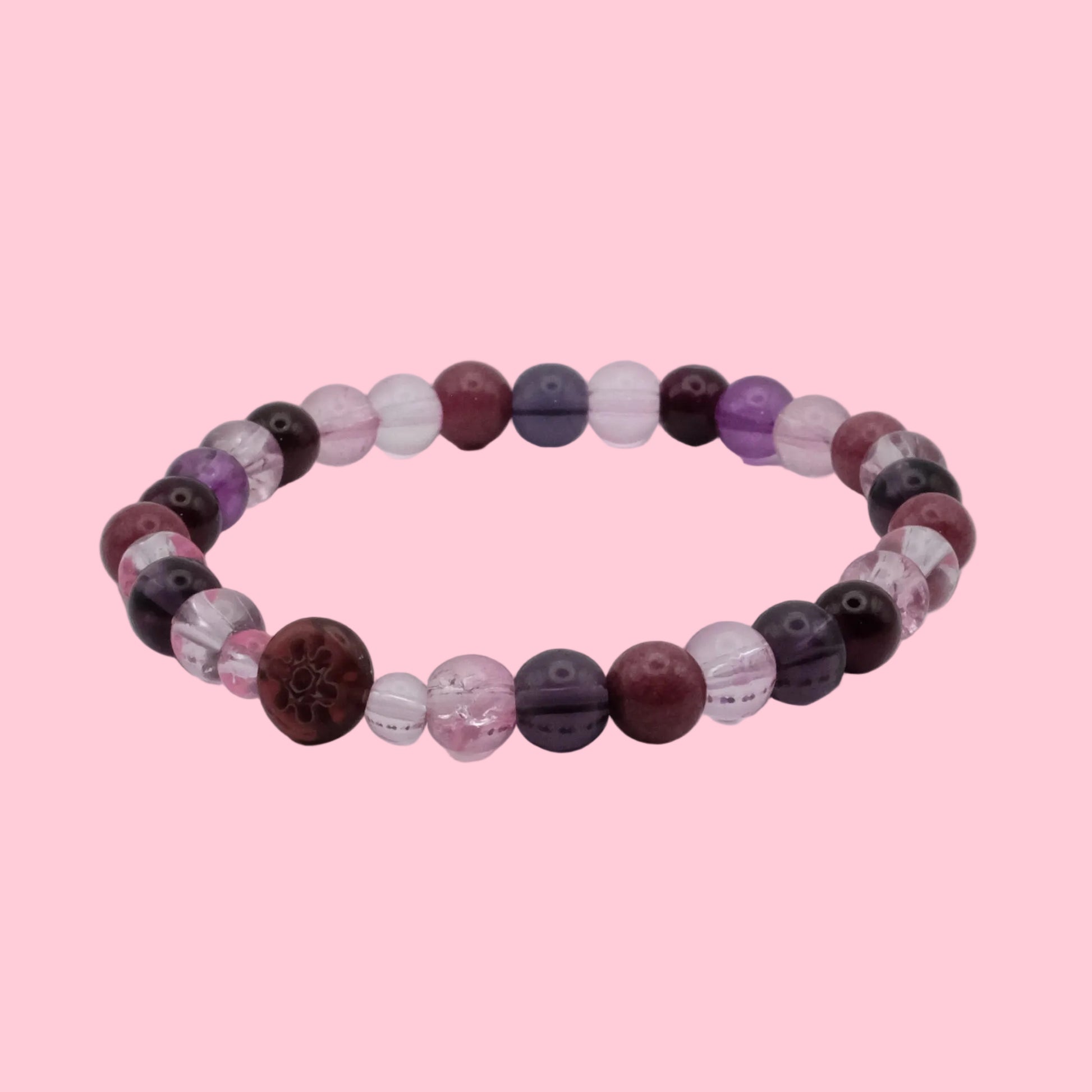 An elastic beaded bracelet composed of 6mm blush pink, plum, mauve and deep burgundy beads, featuring a mix of translucent, frosted and marbled finishes with a burgundy floral accent bead, shown on a clean white background.