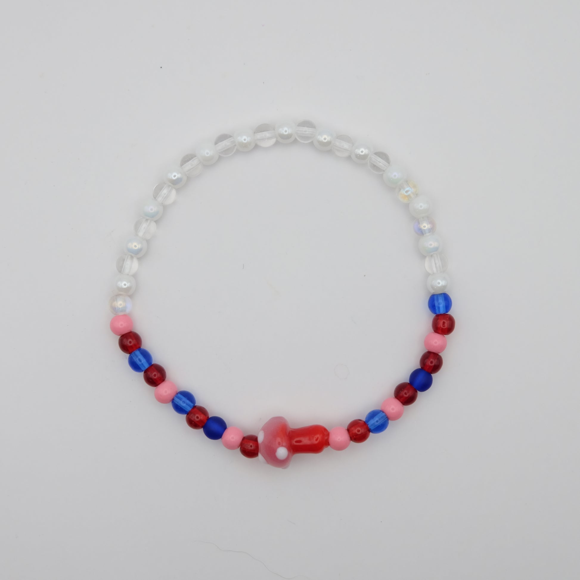 Beaded necklace with red, blue, and pink beads on a light gray background