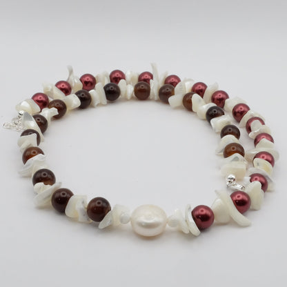 A handmade beaded necklace featuring alternating brown and metallic burnt red 8mm glass beads, mother of pearl chips and a freshwater pearl focal bead, displayed on a white background.