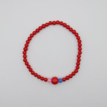 Red beaded bracelet with pink and blue accents on a white background
